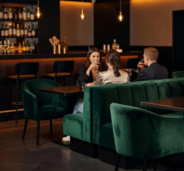 Sfeervolle barruimte van Lumiar Room met warme verlichting en tafels.